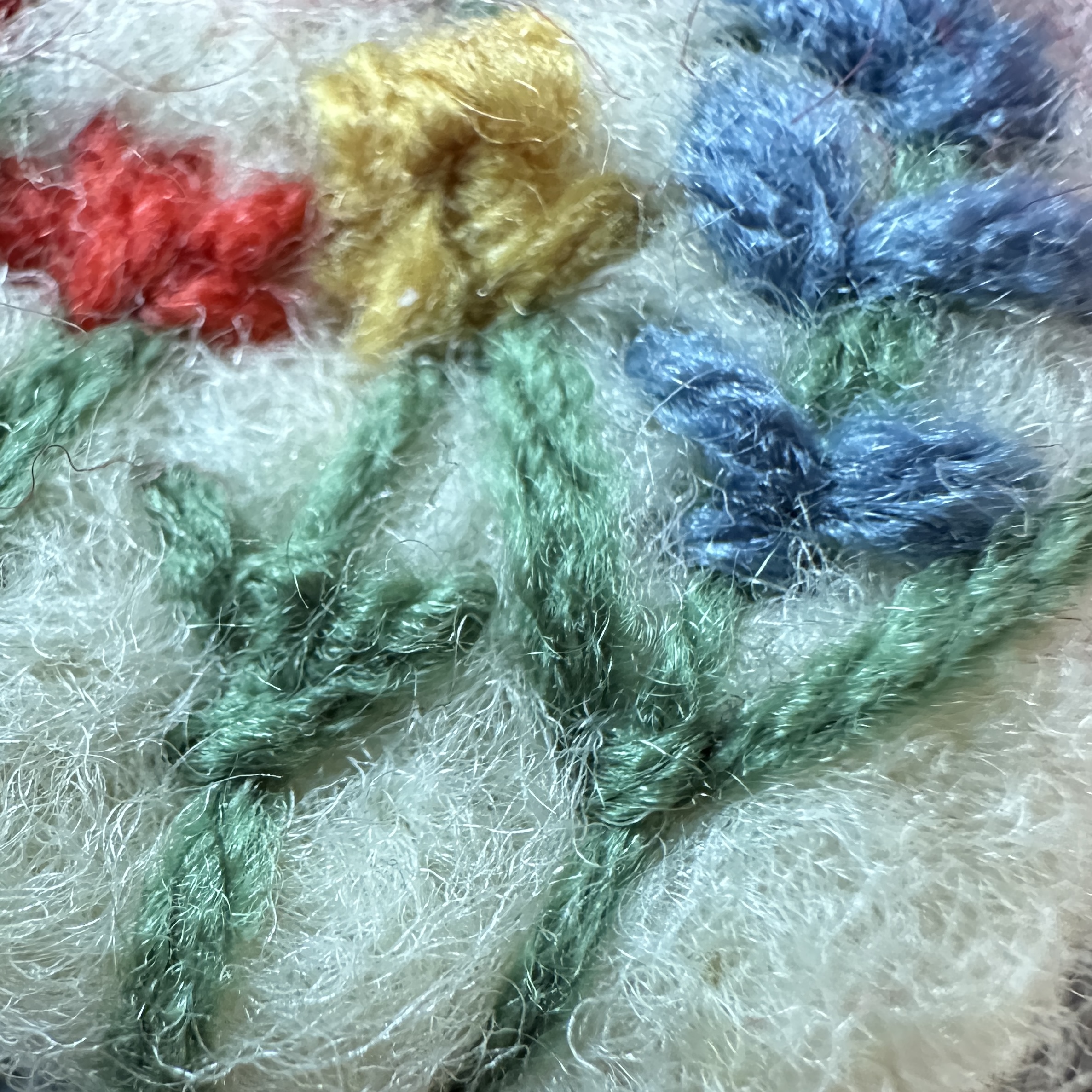 Детайлна снимка на стръкове и цветя от вълна, демонстрираща техниката иглонабиване.